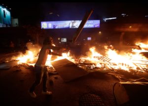 A Lebanese demonstrator burns wood and debris during a protest against recent tax calls on October 17, 2019 in the capital Beirut. (AFP)