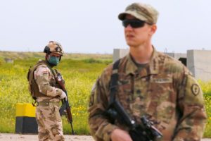 An Iraqi soldier wears a protective face mask and gloves, following the outbreak of coronavirus disease (COVID-19), as he stands guard during the hand over of Qayyarah Airfield West from US-led coalition forces to Iraqi Security Forces, in the south of Mosul, Iraq March 26, 2020. (Reuters)