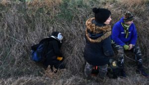 Migrants rest in a ditch, after crossing from Turkey to Greece, near the border crossing of Kastanies. (Reuters)