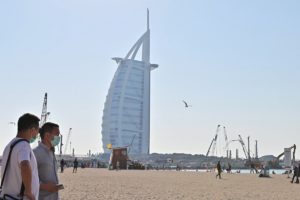 Tourists wearing surgical masks are pictured on a beach next to Burj Al Arab in Dubai on January 29 2020. (AFP)