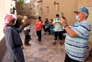 A mask-clad Israeli tourist photographs a falconer holding a falcon during a visit to the historic al-Fahidi neighborhood of Dubai on January 11, 2021. (AFP)