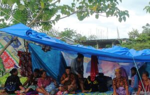 Locals who fled to higher ground are seen at a temporary shelter following an earthquake in Mamuju. (Reuters)