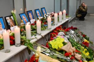 A man sits by a memorial for the victims of the Ukraine International Airlines Boeing 737-800 crash in the Iranian capital Tehran. (AFP)