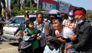 An injured protester is helped by his fellow protesters, at a rally against the military coup. (File photo: Reuters)