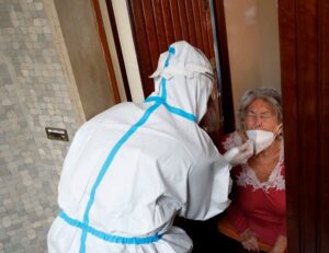 A medical worker visit the home of a patient suspected to be suffering from the coronavirus disease to carry out a swab test, Rome, Italy, December 3, 2020. (Reuters/Remo Casilli)