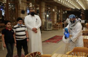 A worker wears a protective suit, following the outbreak of the coronavirus disease (COVID-19), sterilizes the tables before the customers sit down after a restaurant reopened, in Riyadh. (File photo: Reuters)