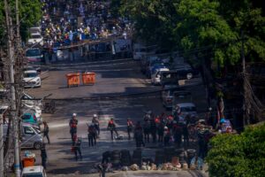 Anti-coup protesters standing behind barricades standoff with a group of police in Yangon, Myanmar Thursday, March 4, 2021. (AP)