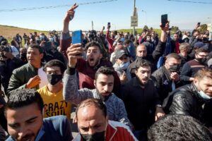 People protest outside al-Hussein New Salt Hospital in the town of Salt, northwest of Jordan's capital, on March 13, 2021. (AFP)