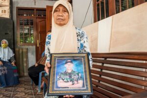 Sarikem holds a photo of her grandson Gunadi Fajar Rahmanto at their home in Yogyakarta on April 26, 2021, a crew member of the submarine that disappeared off the coast of Bali and has been found cracked into pieces on the seafloor with all 53 crew killed in the disaster. (File photo: AFP)