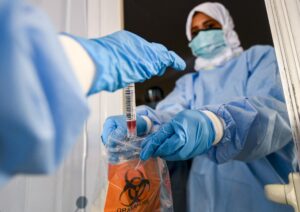 Laboratory workers bag a biological sample at a drive-through COVID-19 coronavirus testing centre in al-Khawaneej district of the gulf emirate of Dubai, UAE. (File photo: AFP)