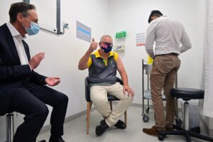 Australia's Prime Minister Scott Morrison reacts after receiving a dose of the Pfizer/BioNTech Covid-19 vaccine, as Minister for Health Greg Hunt (L) looks on, at the Castle Hill Medical Centre in Sydney on February 21, 2021.