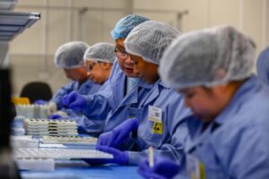 Employees work on the production line of a coronavirus home test unit in Brisbane. (AFP)