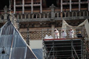 Workers use their phones on a scaffolding at Notre Dame cathedral, Thursday, April 15, 2021 in Paris. (AP)